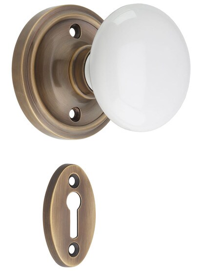 Classic Rosette Mortise Lock Set with White Porcelain Knobs in Antique-By-Hand.
