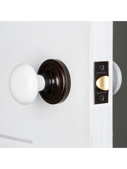 Classic Rosette 2-3/8 in. Backset Timeless Bronze Passage Hall/Closet White Porcelain Door Knob Classic Rosette 2-3/8 in. Backset Timeless Bronze Passage Hall/Closet White Porcelain Door Knob