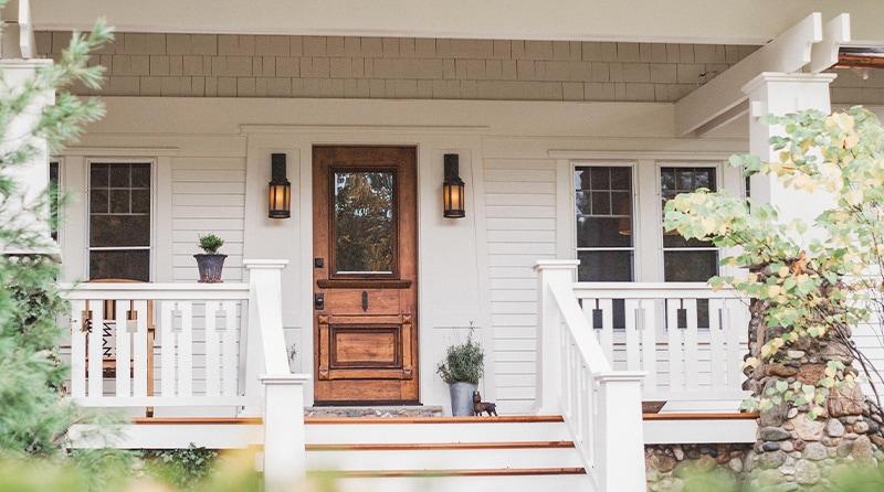 The beautifully renovated porch features new center stairs, railing, and vintage style lighting