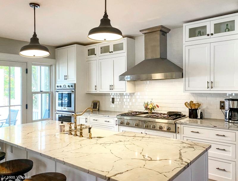 Renovated kitchen with custom cabinets, marble counters and classic brass pulls & switchplates