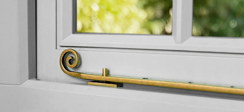 A solid brass rat-tail casement stay adds a traditional touch to this out-swing window.