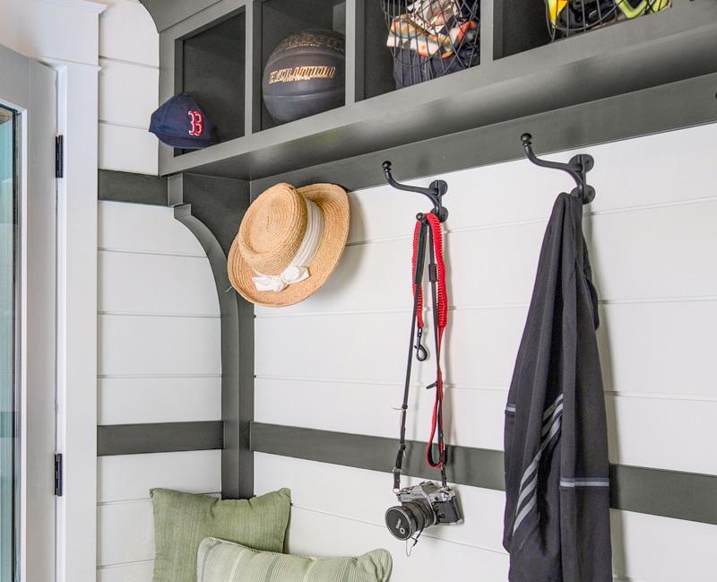 A well-designed mudroom entry equipped with plenty of iron harness hooks.