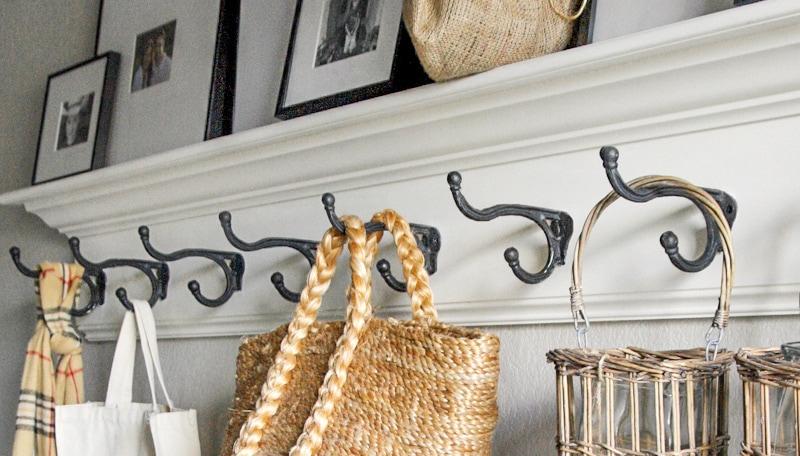 mudroom with row of iron hooks and shelf